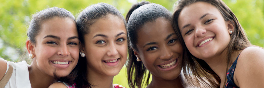 four adolescent girls smiling